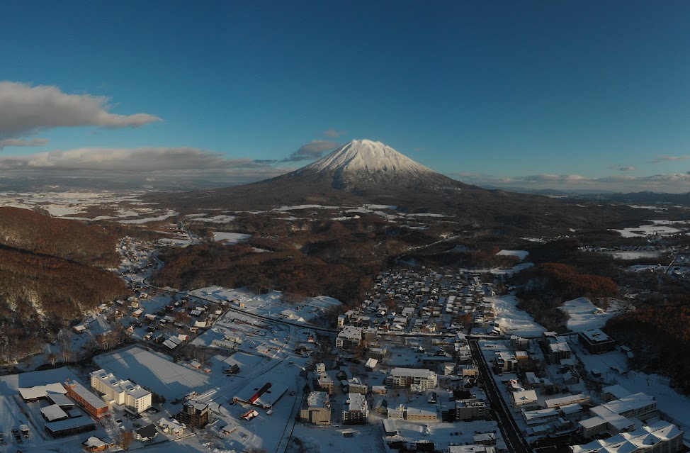 Panoramic winter view of Mount Yotei framed perfectly by large living room windows.