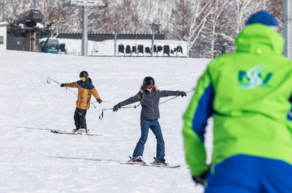 Beginner skier taking a ski lesson on an easy run in Niseko, Japan
