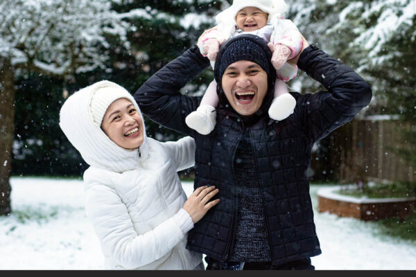 Family enjoying a winter holiday with kids in Niseko, Japan, surrounded by snowy mountains and ski slopes.